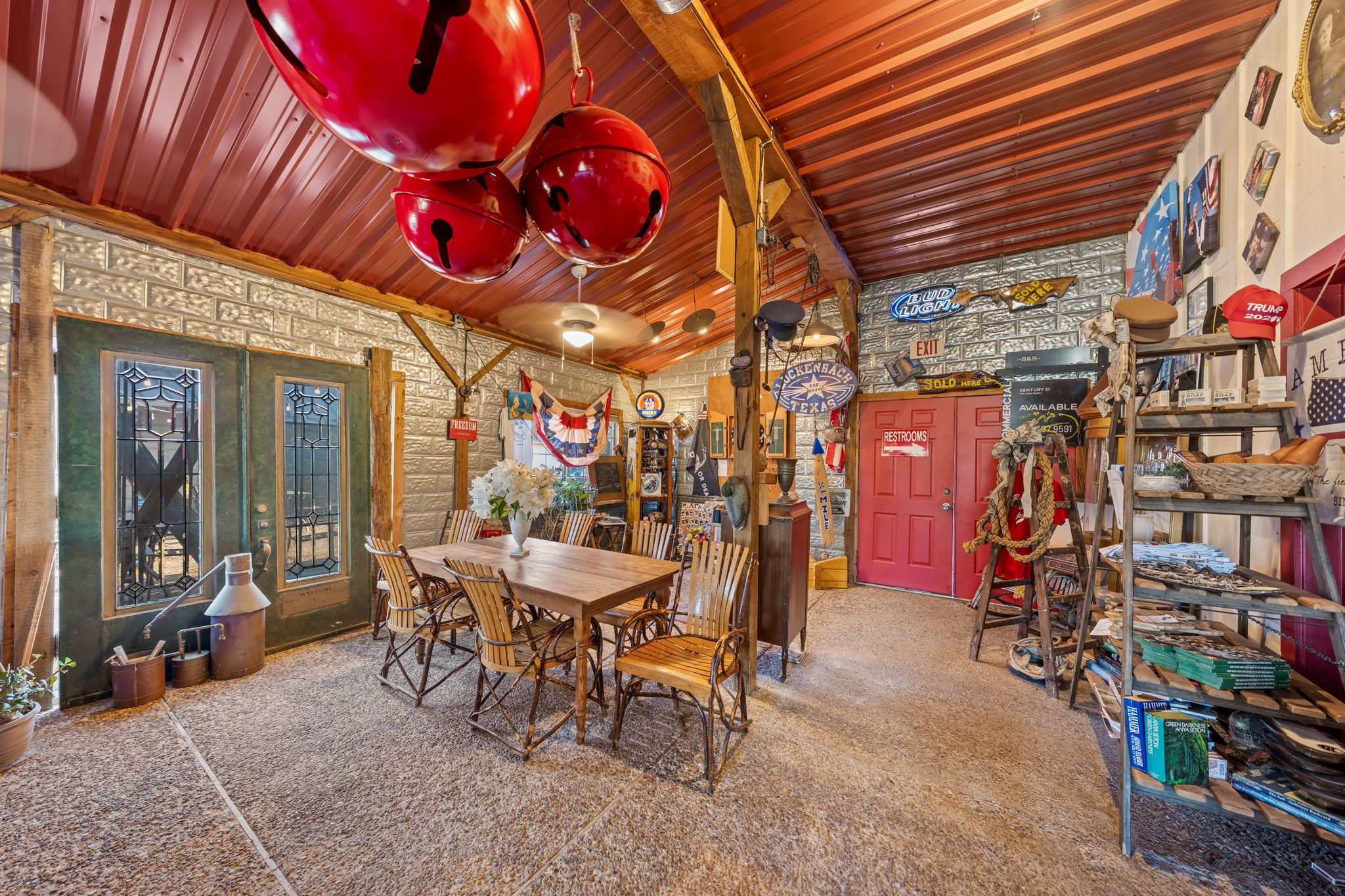 A rustic interior with a wooden table and chairs, a red door, and various decorative items.