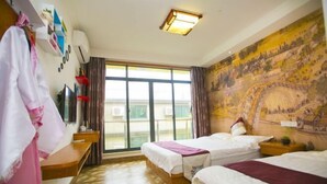 A hotel room with two beds, a large window, a mural on the wall, and a desk with a chair. - Shengsi Jun from the Inn (Shengsi)