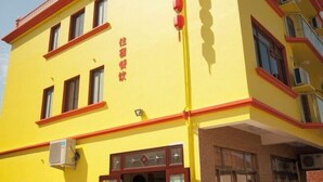 A yellow building with red trim and multiple windows. - Shengsi Jun from the Inn (Shengsi)