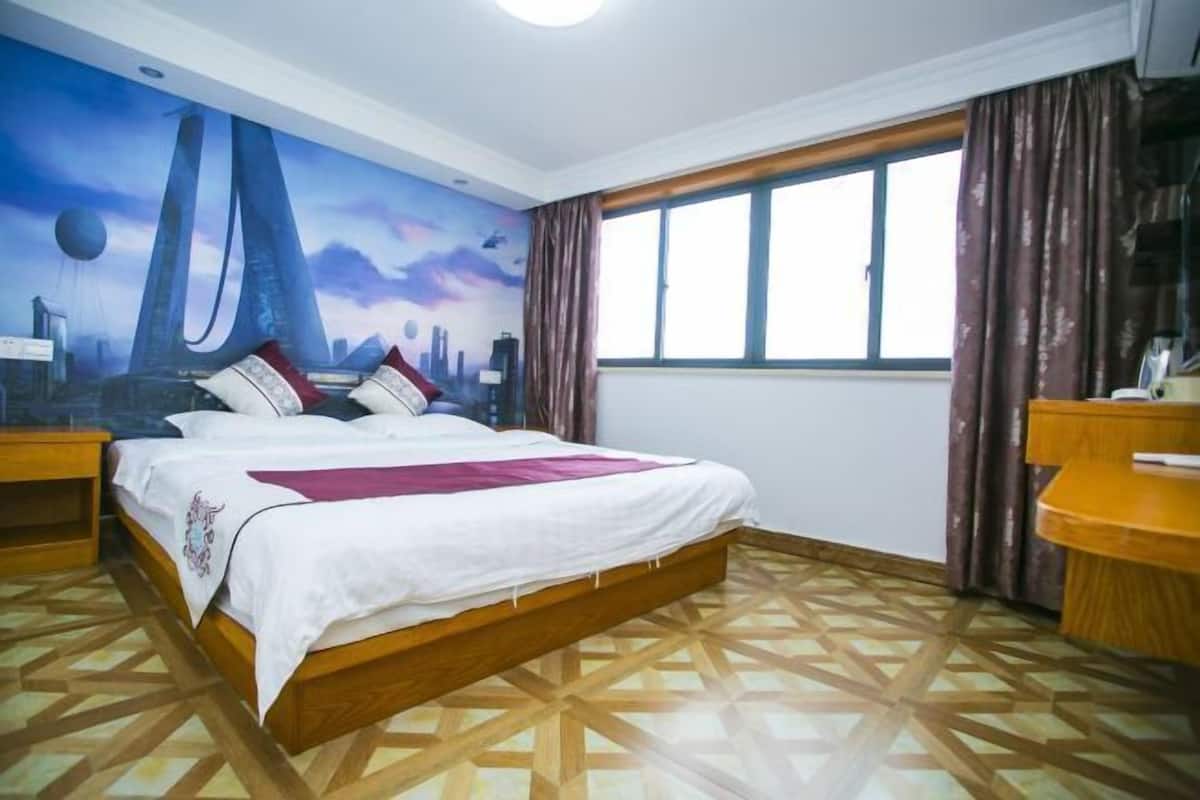 A bedroom with a bed, a nightstand, a window with curtains, and a wall mural.