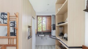 Eine kleine Küche mit Spüle, Arbeitsplatte und Holzschränken.
