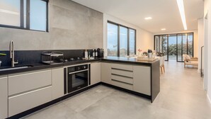Una cocina moderna con una isla grande, horno empotrado y amplio espacio en la encimera.