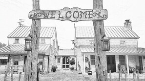 A black and white illustration of a building with a sign that reads 'WELCOME HOME.'
