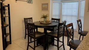 Un coin repas avec une table ronde, six chaises, un globe terrestre, une pagaie et une pancarte « Bienvenue ».
