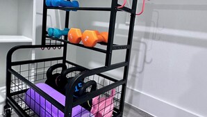 A black metal rack with multiple shelves holding dumbbells and kettlebells. - 3 comfy king beds, hot tub, EV, cozy (Fort Worth)
