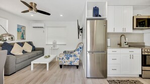 A modern kitchen with white cabinets, a stainless steel refrigerator, and a microwave. - Renovated One Bedroom Apt, Steps From The Beach (Hollywood)
