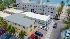 A multi-story hotel with a parking lot, a beach view, and a pool area. - Cozy two bedroom, feet from the beach (Hollywood)