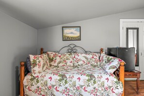 A bedroom with a bed, a television, and a door.