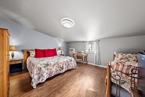A bedroom with a bed, desk, chair, and a window. - Wildflower Suite sleeps 4, by the wine trail, Luckenbach, & Fredericksburg! (Fredericksburg)
