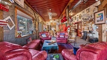 A cozy room with leather sofas, a coffee table, and a rustic wooden ceiling.