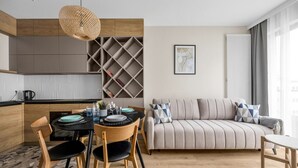 Ein modernes Wohnzimmer mit einer Couch und einem Essbereich mit Tisch und Stühlen.