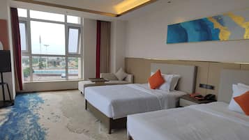 Quarto de hotel com duas camas, uma janela grande com vista, televisão de tela plana e um quadro na parede.