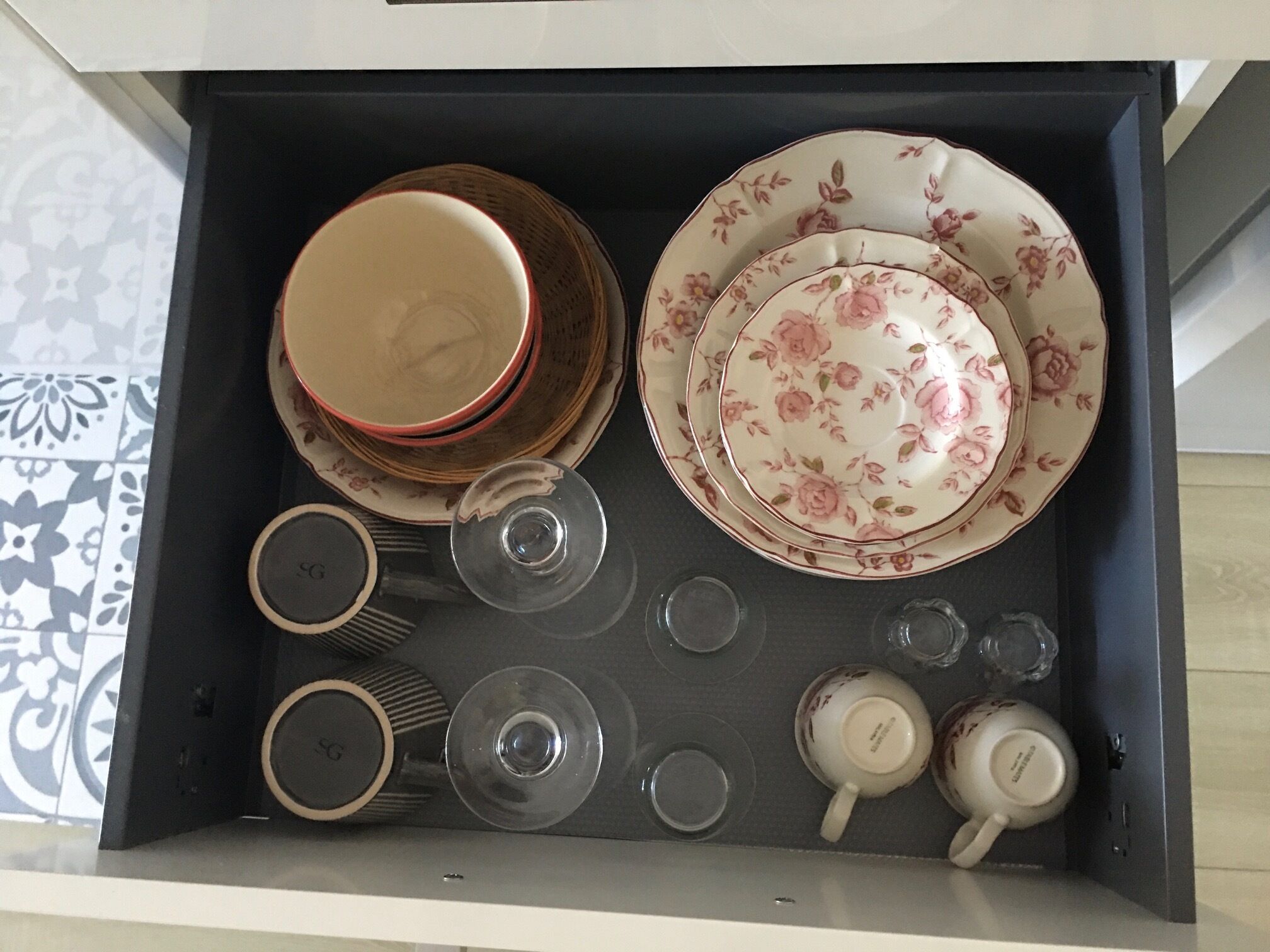 En skuffe med diverse tallerkener, skåle og glas.