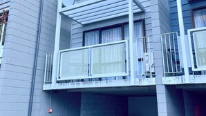 A multi-story residential building with a balcony on the second floor. - OK Holiday Unit #5 - Queenstown Holiday Apartment (Queenstown)