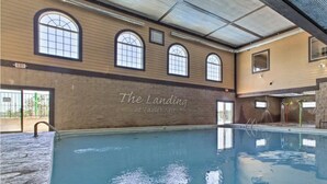 Une piscine intérieure dotée de fenêtres en arc de cercle et d’une enseigne indiquant : « The Landing at Eagle’s Nest ».