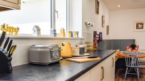 Una cocina con tostadora, bloque de cuchillos y ventana con vista.