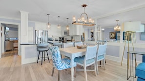 A modern kitchen with white cabinetry, a central island, and pendant lighting. - 118 Seascape by Avantstay Pool + Oceanfront Views (Isle of Palms)