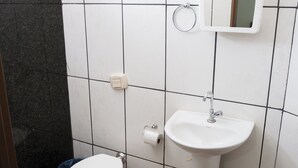 A bathroom with a toilet, sink, and mirror. - Hotel Portela III (Olímpia)