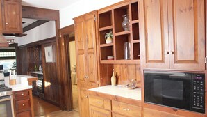 Une cuisine avec des meubles en bois, un four à micro-ondes et une cuisinière.