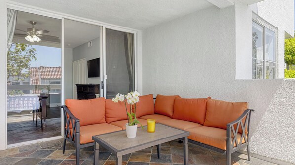 An outdoor seating area with a sofa, a table, and a potted plant. - Encantamar Escape by Avantstay Prime Location + Community Amenities (Laguna Niguel)