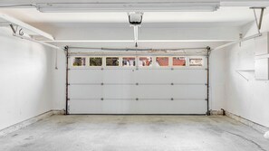 A garage with a white door, metal shelving, and a ceiling light fixture. - Encantamar Escape by Avantstay Prime Location + Community Amenities (Laguna Niguel)
