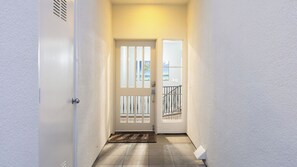 A hallway with a white door, a doormat, and a view of the outside. - Encantamar Escape by Avantstay Prime Location + Community Amenities (Laguna Niguel)