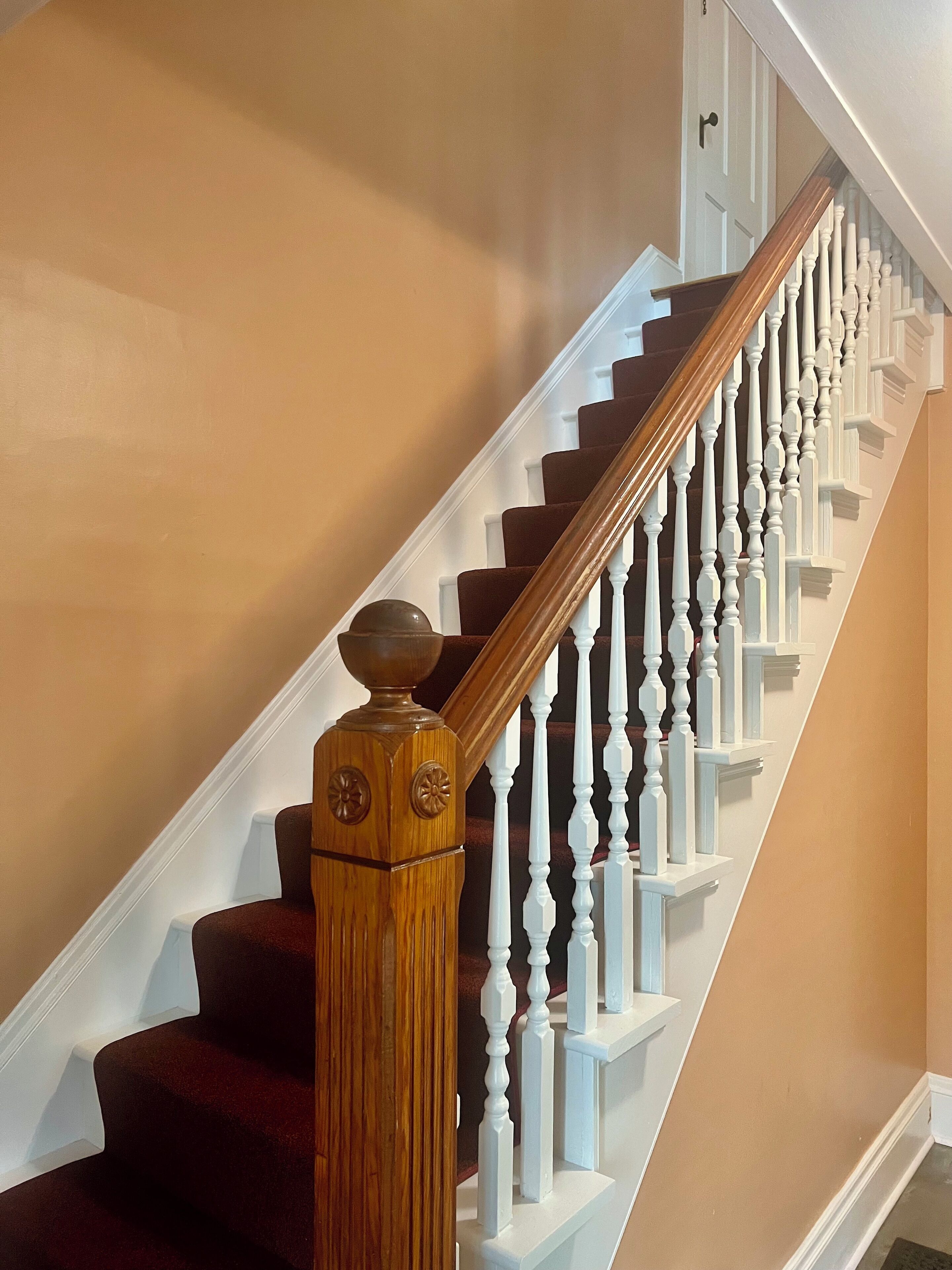 A staircase with white balusters and a wooden handrail.