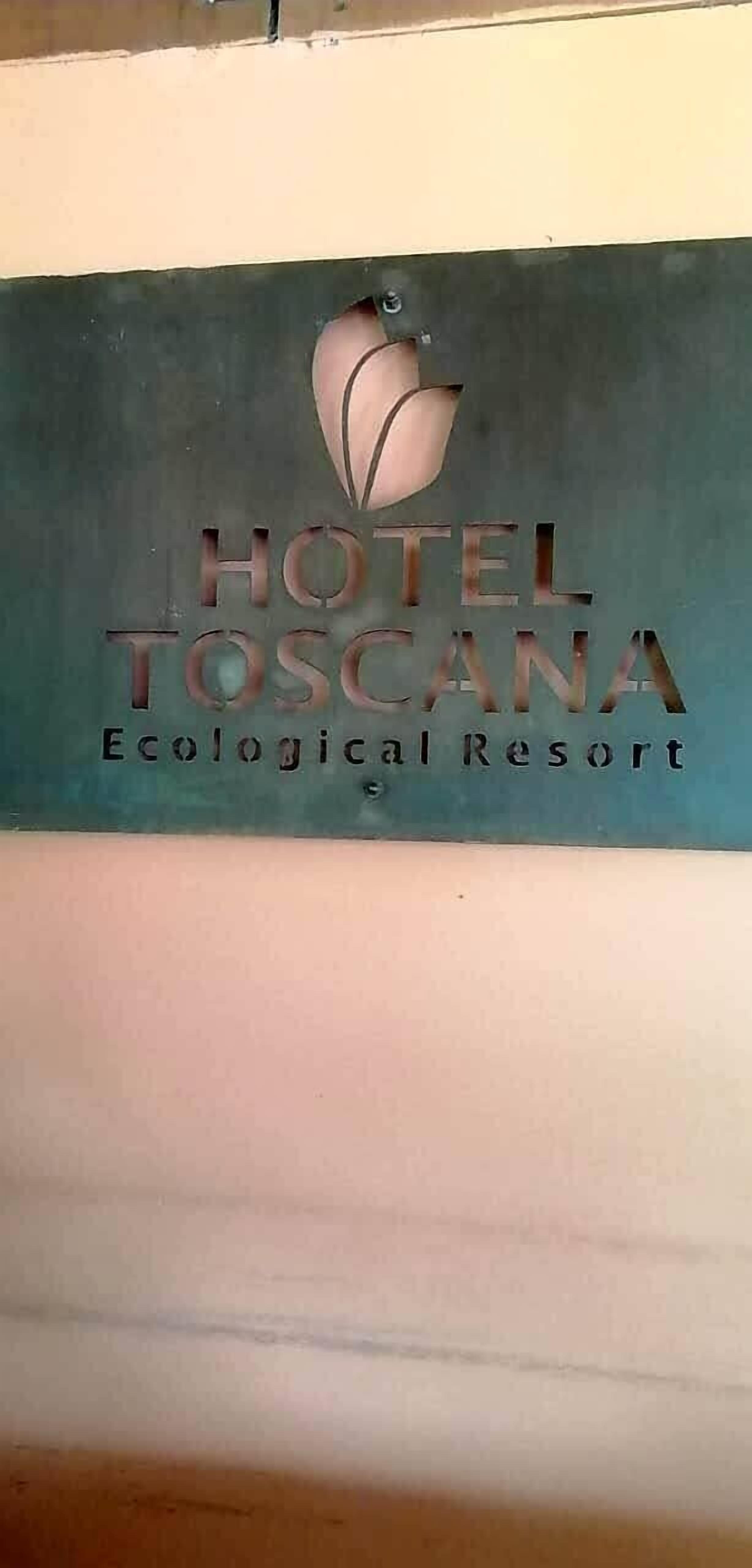 A sign for Hotel Toscana Ecological Resort with a leaf logo.