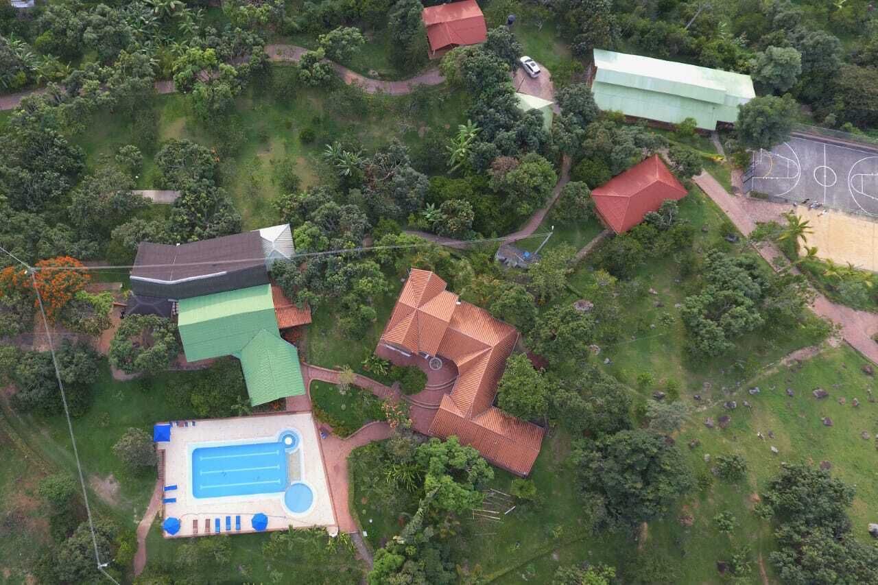 An aerial view of a residential area with multiple houses, a swimming pool, and a basketball court.