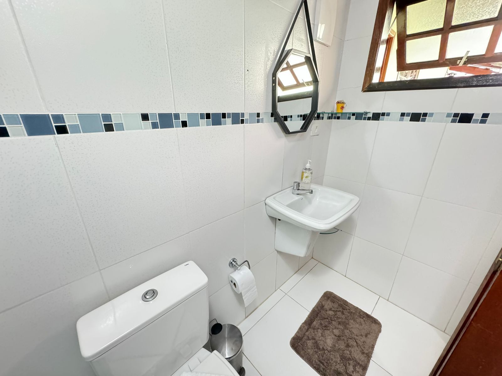 Un baño con inodoro, lavabo y espejo.