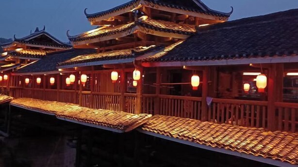 A traditional Chinese building with multiple tiers and ornate roofs, illuminated by warm lighting. - Sanjiang Qingtian Yuese Homestay (Sanjiang)