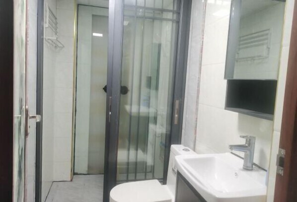A small bathroom with a toilet, sink, and glass shower enclosure. - Sanjiang Qingtian Yuese Homestay (Sanjiang)