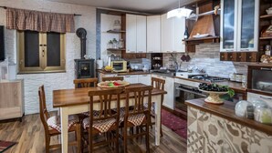 Una cucina moderna con mobili in legno, un tavolo da pranzo con sedie e un piano cottura integrato.