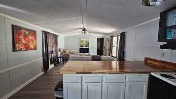 Une chambre d’hôtel spacieuse, dotée d’une grande table à manger en bois, d’un canapé et d’un téléviseur.
