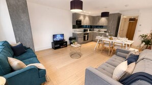 A modern living room with a sofa, a coffee table, and a television.