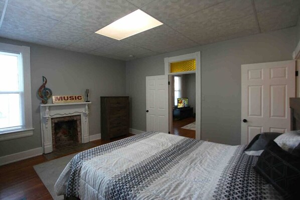 A bedroom with a bed, a fireplace, and a door leading to another room. - Our Laffin' Place (Chillicothe)