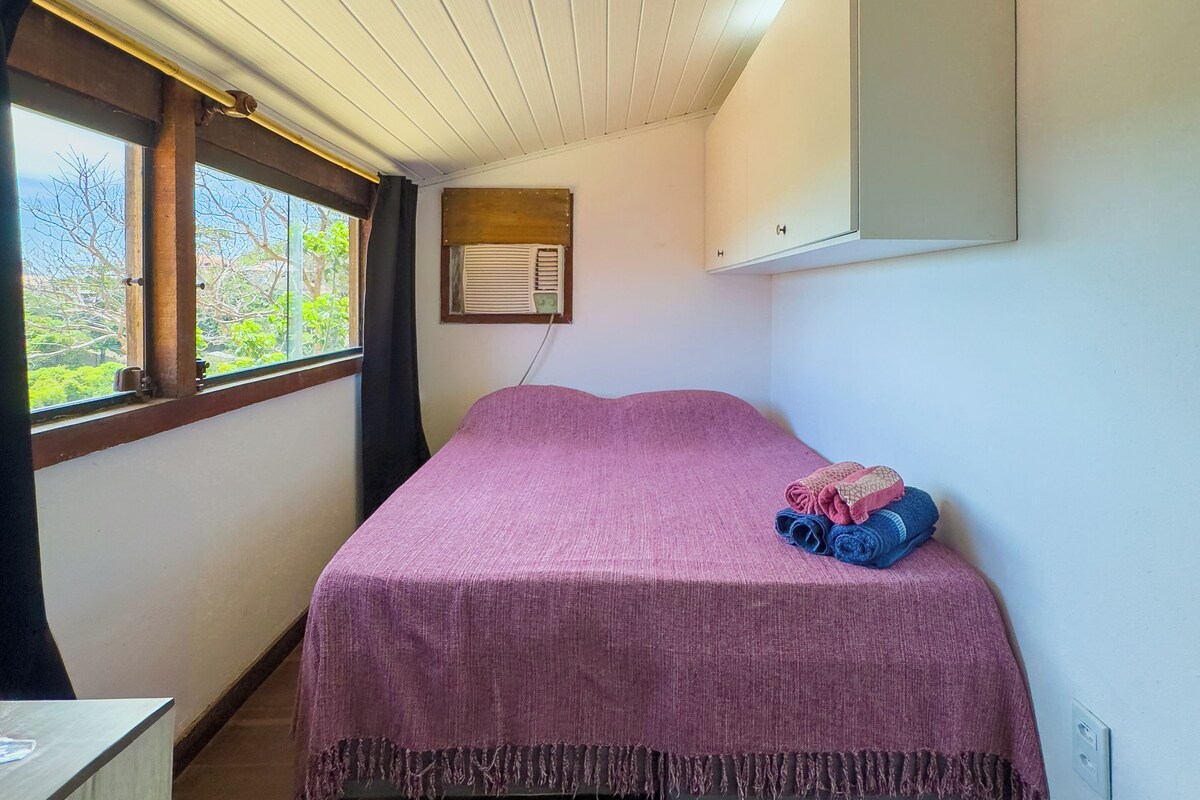 Une chambre à coucher avec un lit, une fenêtre, un miroir et un plafond en bois.
