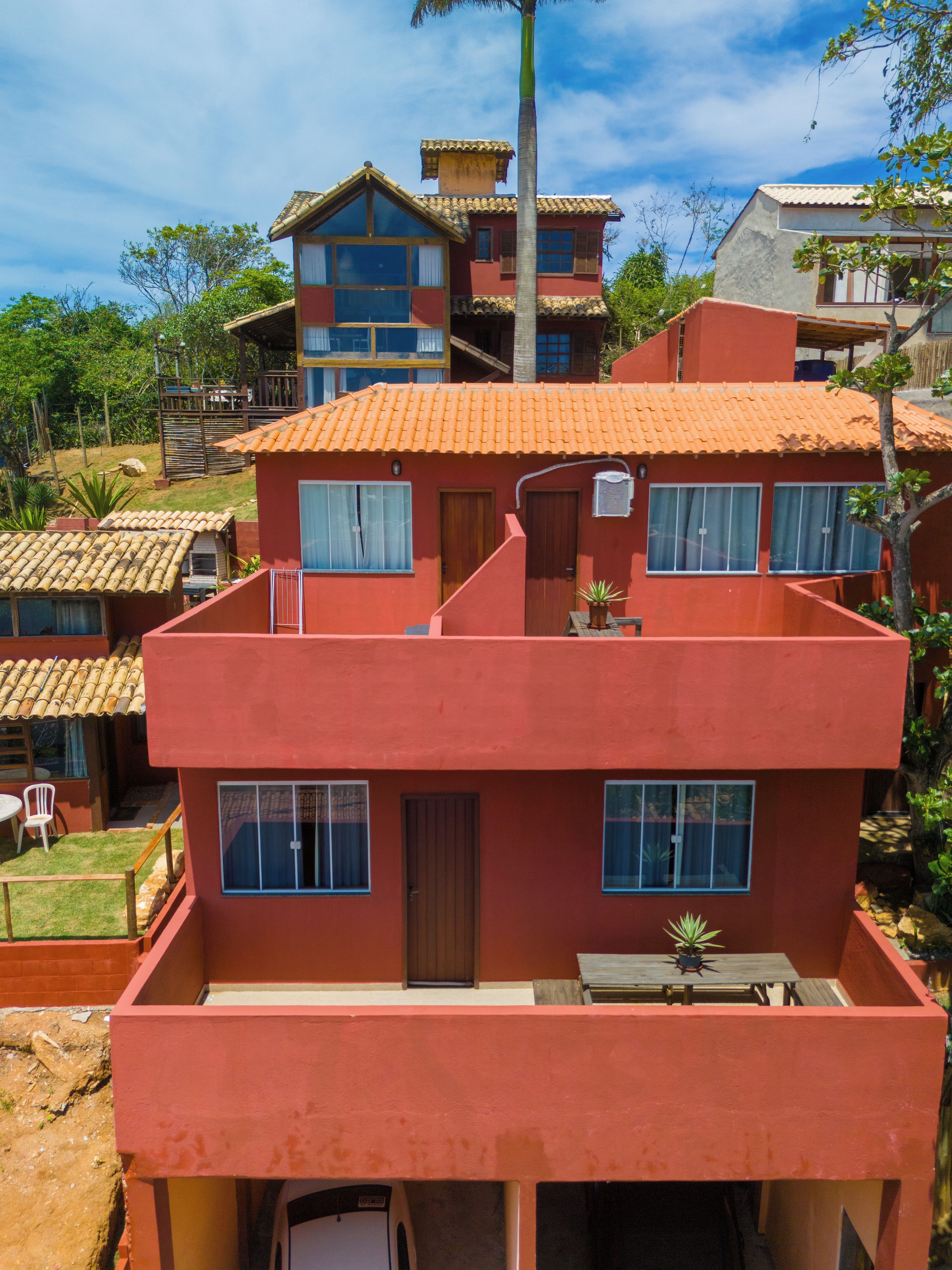 Un edificio de varios pisos con fachada roja, múltiples ventanas y techo plano.