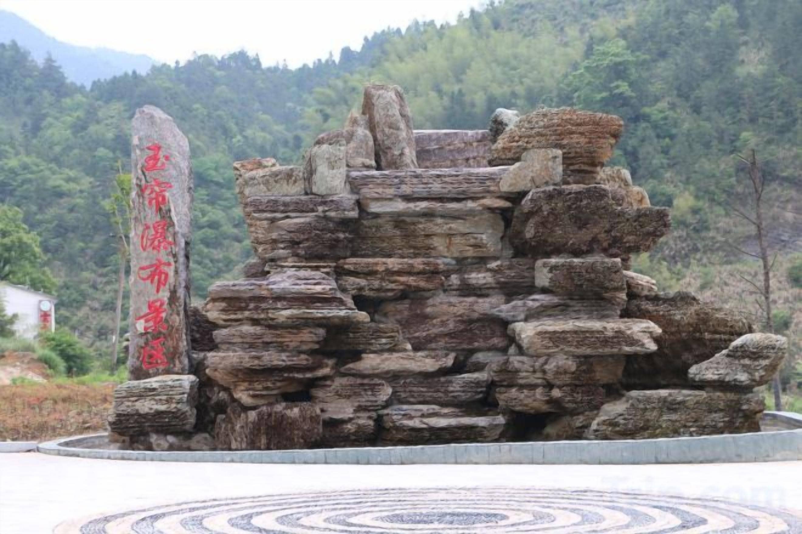 A stone structure with inscriptions, surrounded by a circular patterned floor.