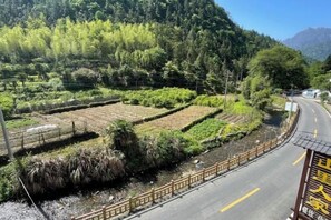 A rural landscape with terraced fields, a winding road, and a wooden fence. - Shanlirenjia Inn Sanqingshan (Yushan)