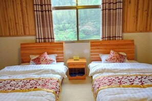 A room with two beds, wooden headboards, and a window with curtains. - Shanlirenjia Inn Sanqingshan (Yushan)
