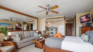 A hotel room with a bed, a sofa, a coffee table, a TV, and a ceiling fan. - KBM Resorts: Papakea Pke-304 Renovated Studio With Ocean Views! (Kaanapali)