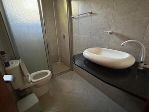 A bathroom with a toilet, a sink, and a shower. - Enkishon Suites - 1 
 (Kiambu County)