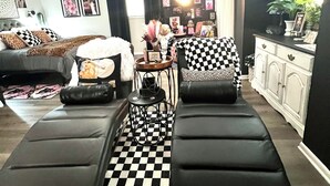 Un salon avec un sol à carreaux, un canapé, une table basse et un ventilateur de plafond.