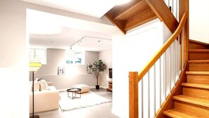 Un salon moderne avec un escalier menant à l’étage supérieur.
