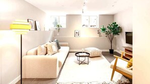 Un salon moderne avec un canapé, une table basse et un téléviseur.