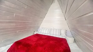 A room with a bed, white walls, and a red blanket. - Chalé Rústico 8 min do centro turístico (Campos do Jordão)