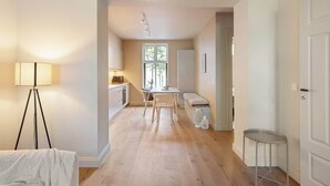 Une cuisine moderne avec un coin repas, un petit espace détente et une fenêtre bien visible.
