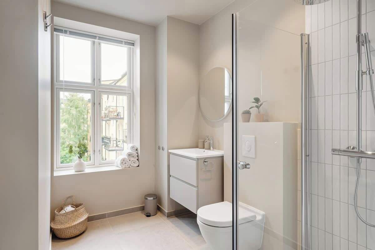 A modern bathroom with a toilet, sink, and shower.