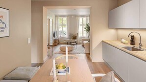 Une cuisine moderne avec une table à manger en bois, un évier intégré et une vue sur l’espace de vie.
